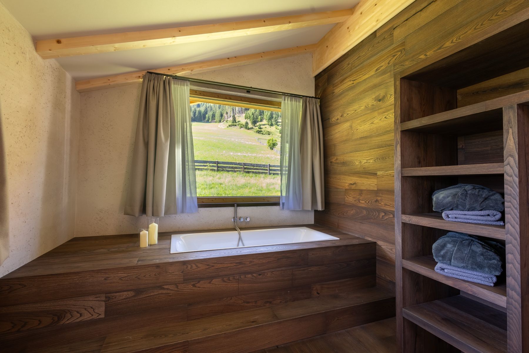 Badewanne in Holz mit Blick auf eine Bergwiese